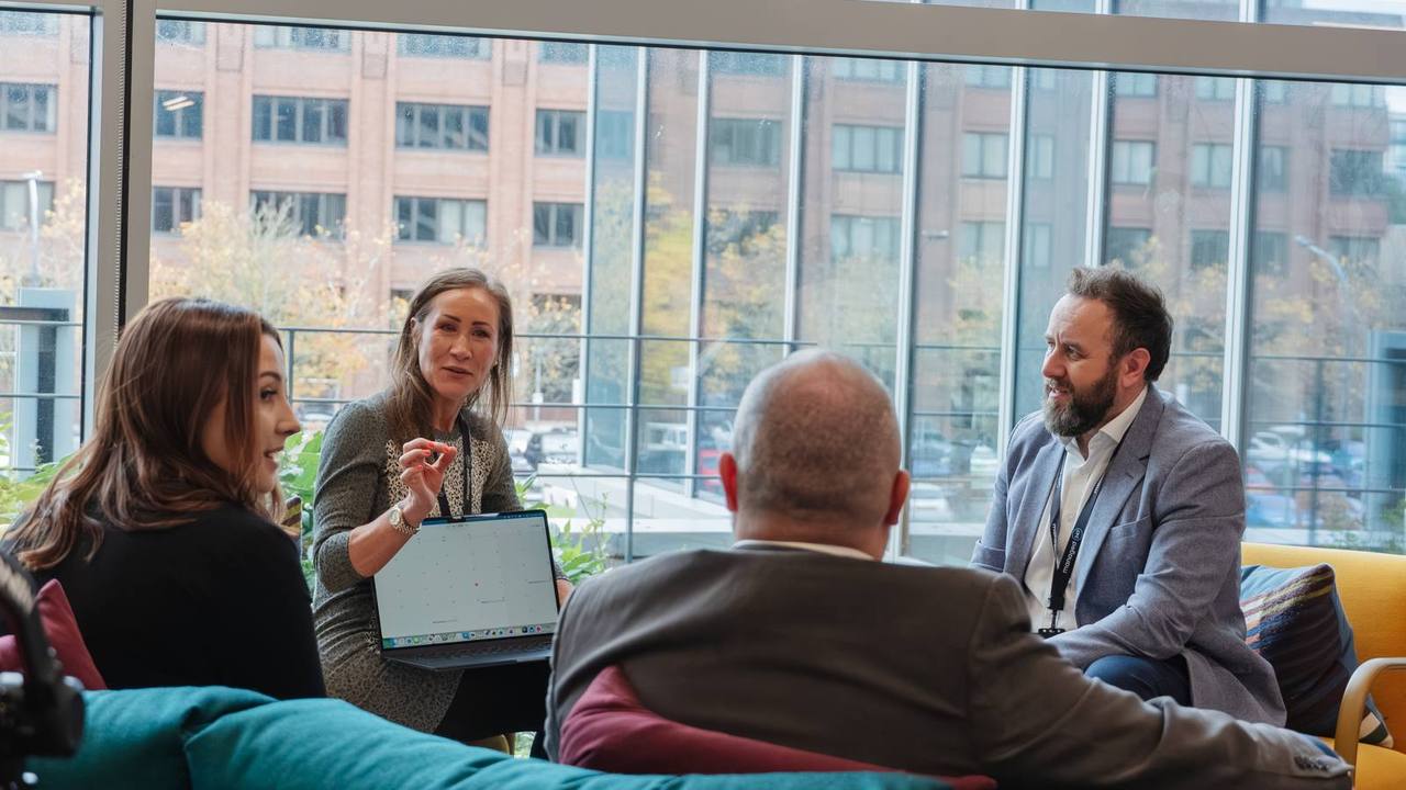 Managed247 engineers in conversation around a laptop in one of our UK offices